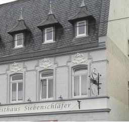 Nahaufnahme der Fassadenbeschriftung 'Gasthaus Siebenschläfer'